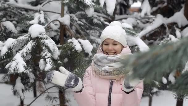 Портрет красивой европейской женщины, хлопающей в ладоши в варежках, посреди зимнего леса замедленного движения — стоковое видео