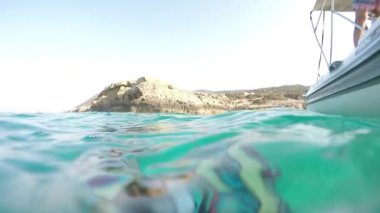 POV gezen bir motorlu tekne ve bir kayanın yanında denize vurmuş. Yaşam tarzı, aktif dinlenme. Ağır çekim