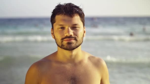 Portret beztroski brunetka młodego człowieka z przyrodą, w tle morza. Zwolnionym tempie — Wideo stockowe