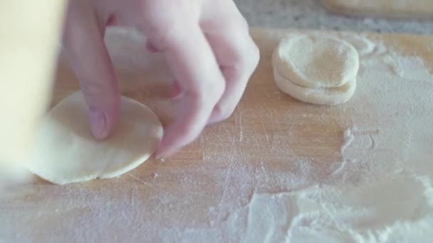 Közelkép női kezek roll a tésztát vékonyan a főzés gombóc az asztalra, sodrófa használandó — Stock videók