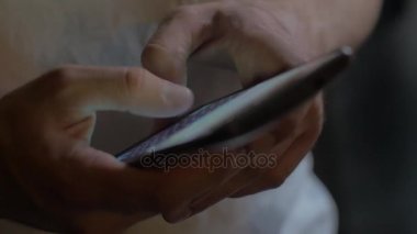 Yakın çekim, bir adamın ellerini kullanan bir akıllı telefon, cep telefonu, yazar mesaj bir adam tutar