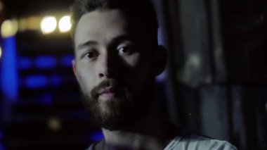 Portre sakal ve bir gece kulübünde bir rock band müzik performansı sırasında şık bir saç modeli ile ciddi bir genç adam. Düşük anahtar atış.