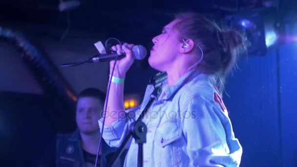 Θηλυκό σολίστ του μουσικού ροκ μπάντα συναισθηματικά εκτελεί ένα τραγούδι κατά τη διάρκεια μιας συναυλίας, αργή κίνηση — Αρχείο Βίντεο