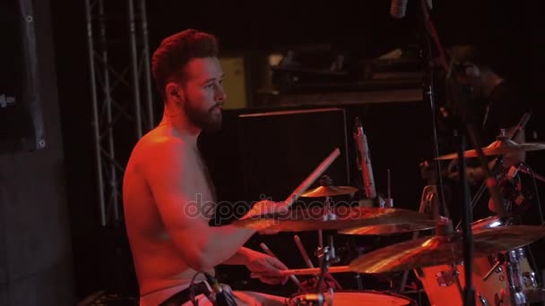 Batterista con barba e busto nudo che suona la batteria durante una performance musicale della rock band, slow motion — Video Stock