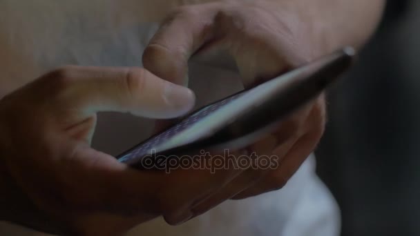 Close-up de um homem mãos usar um smartphone, um homem detém um telefone celular, escreve mensagem — Vídeo de Stock