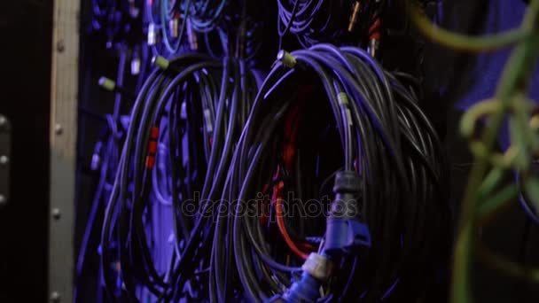 Los cables eléctricos para equipos de sonido se retuercen colgando de la pared en la oficina de técnicos de sonido. Concierto de rock alambres y cables entre bastidores . — Vídeos de Stock