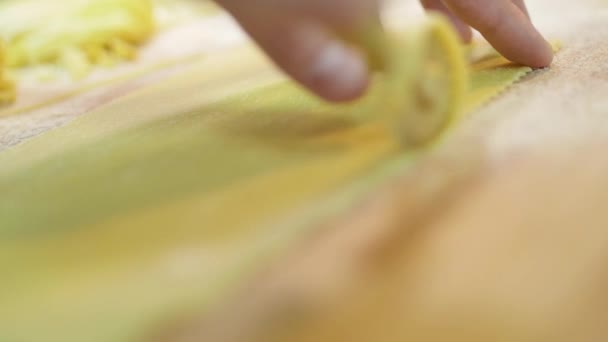 Gros plan des mains des hommes utiliser un couteau à disque professionnel pour les couverts de pâte figurée, pour la cuisson des pâtes, au ralenti 