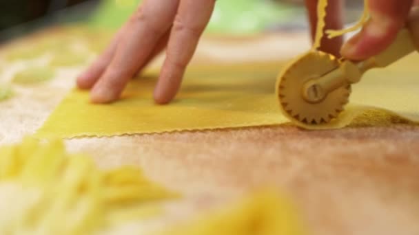 Proceso de corte de una hoja de masa para pasta, utilizando un cuchillo de rodillo profesional para rebanar rizado, primer plano, cámara lenta — Vídeos de Stock