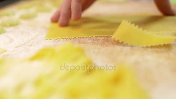Close-up of mens hands use a professional roller knife to cut pasta from a piece of dough, slow motion — Stock Video
