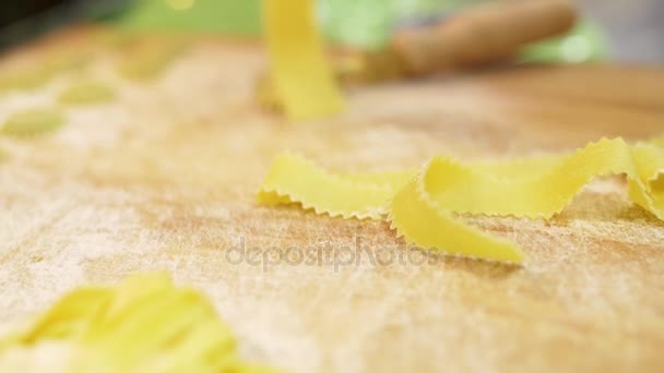 Primer plano de las manos de los chefs cambian la pasta fresca cortada de un pedazo de masa, en cámara lenta — Vídeos de Stock