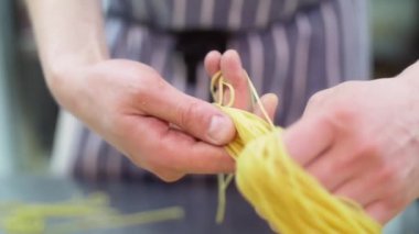 Makarna yuvaya kıvrılıyor. Şef bir hamur elinde, Rüzgar bir yuva kapatır. Ağır çekim. Yakın çekim