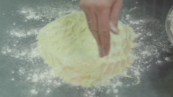 Процес приготування тіста. Чоловічі руки посипають борошном з тіста зверху, крупним планом — стокове відео