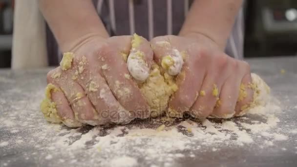 Proces van het kneden van het deeg. Man chef-kok in schort kneedt deeg close-up — Stockvideo