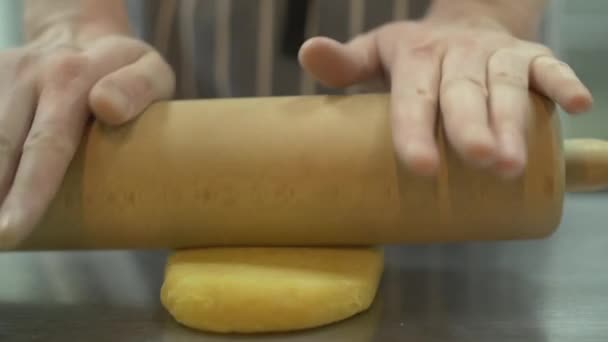 Свежеприготовленное тесто скатывается со скалкой в тонкий слой замедленной съемки, крупным планом — стоковое видео