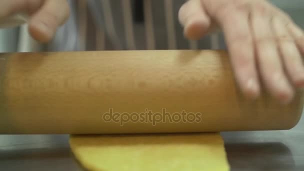 Étaler la pâte pour les pâtes utiliser le rouleau à pâtisserie ralenti close-up. Les mains du chef déploient la pâte fraîchement préparée — Video