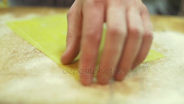 Mens Chef hands cut a thin layer of dough to use a roller professional knife slow motion close up — Stock Video