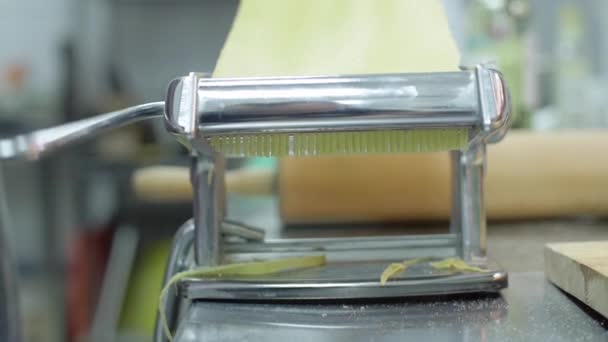 Pasta de espagueti fresca saliendo de la máquina de pasta de cerca. Chef utilizar la máquina de corte de pasta — Vídeo de stock