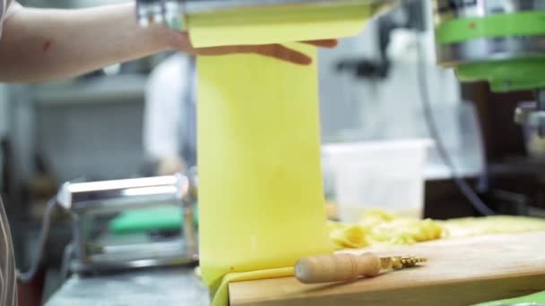 Паста машина в роботі. Тонкий парний шар тіста для приготування макаронних виробів виходить з макаронної машини. Шеф готує тісто для макаронних виробів. Повільний рух — стокове відео