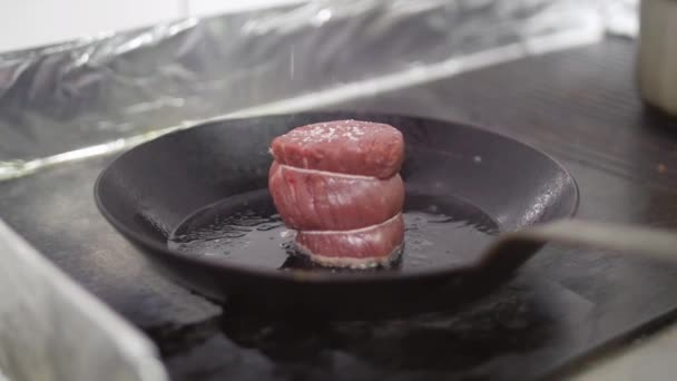 スローモーション新鮮なジューシーな肉ステーキは油を使ってフライパンで揚げられました。肉のステーキの上に振りかける塩 — ストック動画