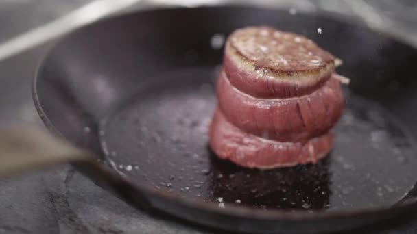 大規模な塩は、新鮮なタイの肉ステーキの上に振りかけた。ジューシーな肉のステーキはフライパンで油で揚げ。スローモーション。クローズ アップ — ストック動画