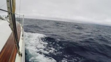 POV yolculuk bulutlu havalarda yelkenli yat. Dalgalar deniz gemi su vurmak