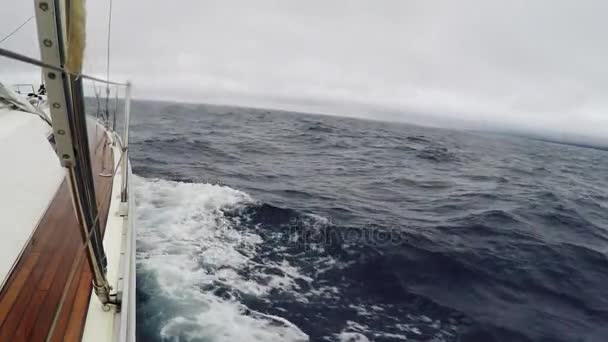 POV Voyage sur un yacht avec les voiles vers le bas par temps nuageux. Des vagues ont frappé le navire de mer, éclaboussant l'eau 