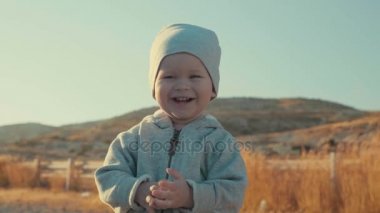 Çok güzel mutlu neşeli Avrupa çocuk açık havada, ağır çekim arka planda dağlar gülümseyen