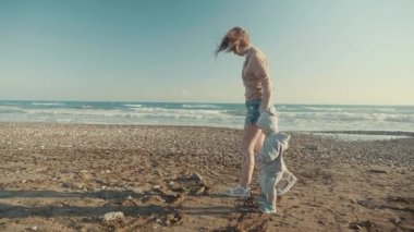 Denize yakın boş ve kıyı Slow Motion Bakımı anne ve küçük oğlu elele yürümek