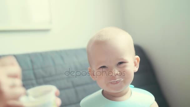 Slow mo Maman nourrit un enfant souriant gai avec une cuillère. Petit garçon heureux au petit déjeuner — Video