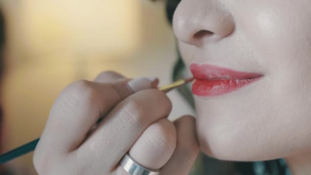 Extreme Close Up рука профессионального визажиста делает макияж губ, использовать помаду, блеск для губ кисти — стоковое видео