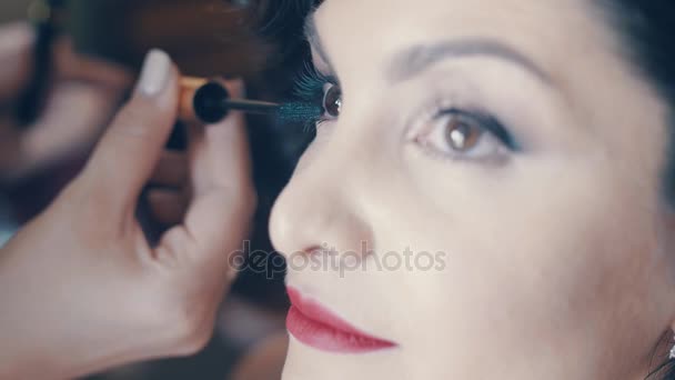 SLOW MO maquiador faz make-up para bela mulher morena. Mão de pestanas de tintura estilista modelo — Vídeo de Stock