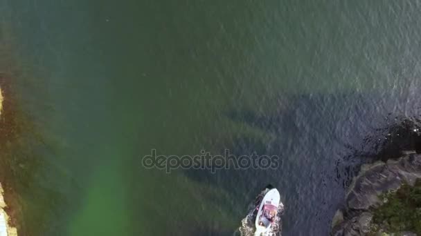 Aerial tiro bonito barco a motor branco navega entre as rochas. Mar límpido turquesa com água pura — Vídeo de Stock