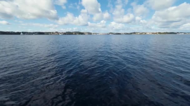 Grande paisagem marinha. Azul claro mar e céu com nuvens brancas. Ilha e vila piscatória no fundo — Vídeo de Stock