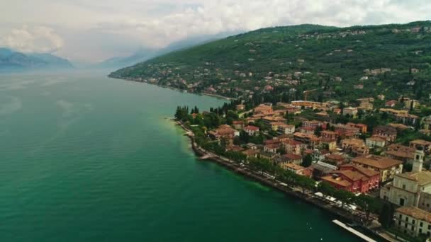 Letecký zpětný záběr krásné malé město s domem nábřeží obklopen vysokou úžasnou horu — Stock video
