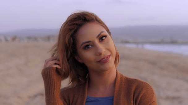 Retrato de una hermosa mujer sonriente jugando al pelo con una emoción positiva posando en la playa — Vídeos de Stock