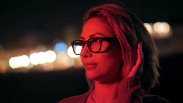 Close up millenial festive young woman contemplating red neon show at night outdoors party — Stock video