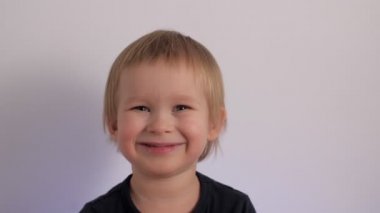 Attractive cheerful baby boy laughing having happy facial expression portrait of cute kid