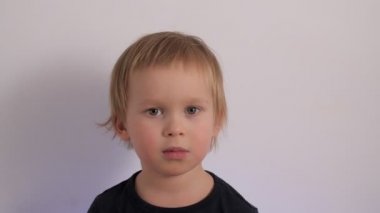 Portrait of thoughtful little boy searching idea scratching head thinking male child