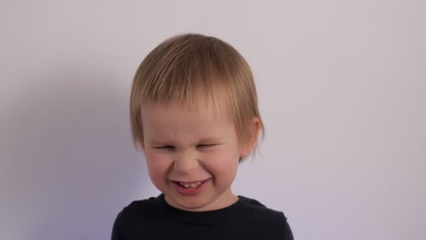 Angry little cute boy posing having negative emotion portrait of cute male baby frowns — Stockvideo