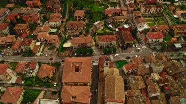Panning aerial shot busy street with car traffic at small old European city shooting from helicopter