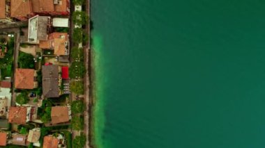 Aerial shot top view beautiful beach coastline surrounded by blue sea water and old city