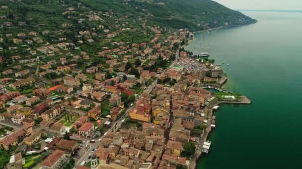 Aerial shot beautiful top view over smooth sea calm surface waterfront surrounded by old small town — Stockvideo