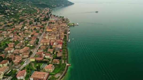 Аэросъемка пролетела над красивой природной морской набережной, окруженной небольшим городом и морем — стоковое видео