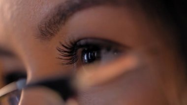 Low angle macro pretty woman putting on stylish glasses for good vision