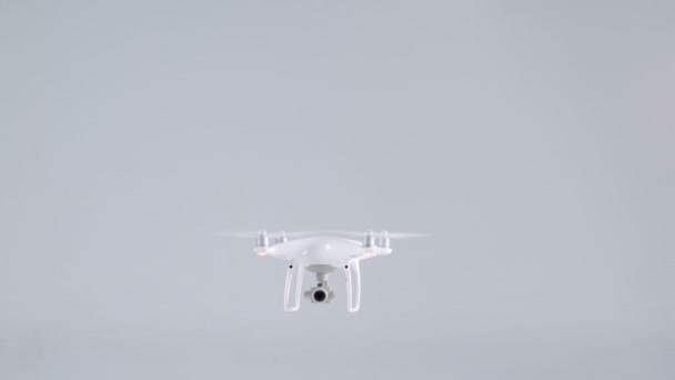 Drone quadcopter sans fil blanc sans pilote avec caméra d'action volant se levant et planant en studio 