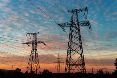 Elektrik direkleri ve gün batımında alacakaranlıkta çizgiler.