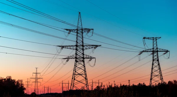 Linhas de energia em um nascer do sol colorido, linhas de energia elétrica contra o céu ao nascer do sol — Fotografia de Stock