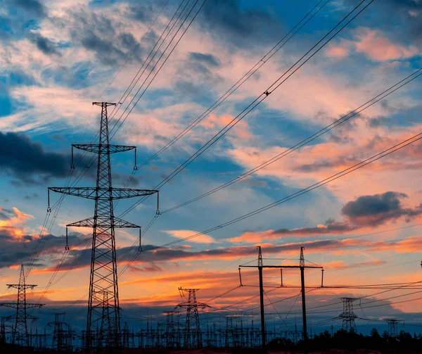 Elektriciteit pylonen en lijnen in de schemering bij zonsondergang. — Stockfoto