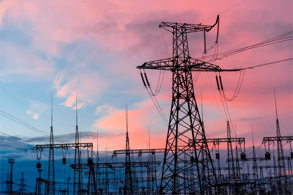 Elektrik direkleri ve gün batımında alacakaranlıkta çizgiler.
