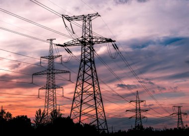 Elektrik direkleri Trafo Merkezi günbatımı sırasında arka plan üzerinde.